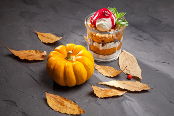 ice cream with pumpkin smoothies on a wooden table next to pumpkin stuck autumn leaves and red...