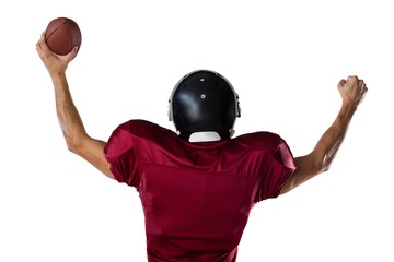 Rear view of sportsman holding football with arms raised