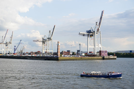 Hafenanlage mit Containerbrücken und Schute