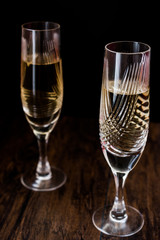 Champagne glasses on dark wooden surface.