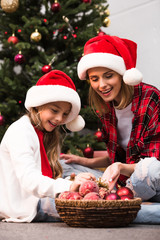 mother and daughter decorating christmas tree