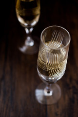 Champagne glasses on dark wooden surface.