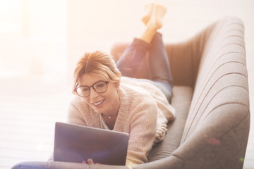 Nice delighted woman looking at the tablet screen