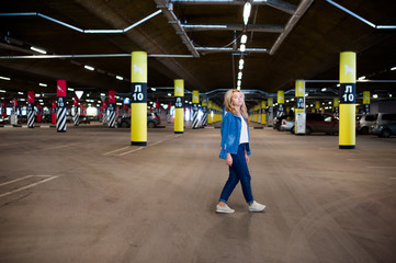 Obraz premium young beautiful woman in jeans clothes in parking of shopping center. portrait of a girl with freckles on her face