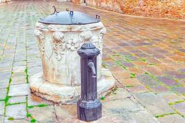 Obraz premium Water intake facilities medieval Venetian wells in the city squares. Venice. Italy.