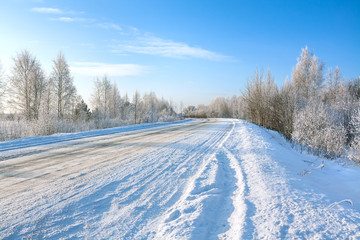 Fototapeta na wymiar winter landscape with asphalt road,forest and blue sky.