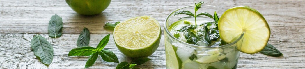 Bannière de cocktail Mojito au citron vert et menthe en verre highball sur fond de bois blanc