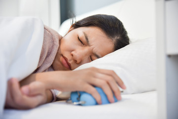 Obraz na płótnie Canvas Sleepy Asian woman holding Alarm clock.