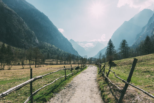 Landscape with valley dirt track and mountains, Mello, Lombardy, Italy