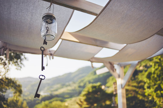 Key wind chime hanging from patio rafter, Lucca, Tuscany, Italy