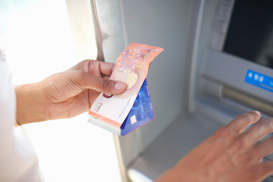 Woman using cash dispenser