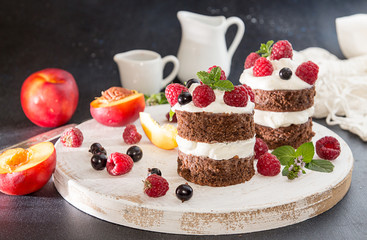Chocolate cake decorated with raspberry, black currant, nectarine, wipped cream and mint.