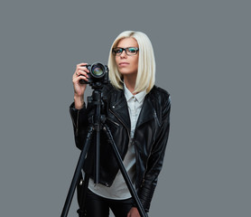 Blond photographer female on a grey background.