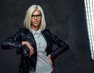Blond photographer female on a grey background.