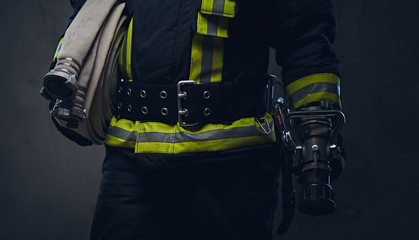 Obraz premium Firefighter in uniform holds fire hose.
