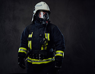 Firefighter dressed in uniform and an oxygen mask.