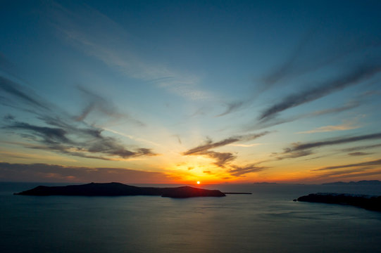Sun setting over sea on horizon, Oa, Santorini, Kikladhes, Greece