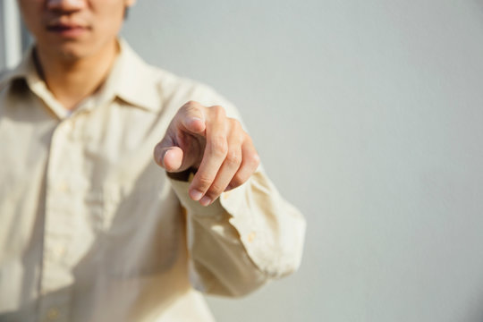 Young man pointing at camera, mid section