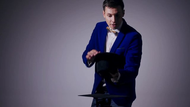 Young illusionist performing tricks with hat and rabbit