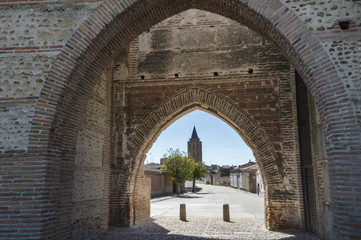 Fototapeta na wymiar Puerta de Cantalapiedra con la Iglesia San Nicolás de Bari al fondo en Madrigal de las Altas Torres, Avila, España