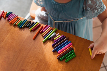 Girl lining up crayons in a row