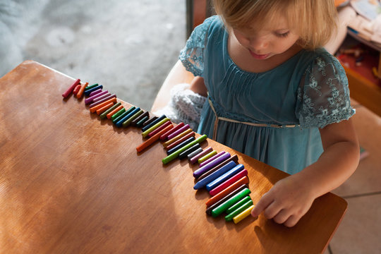 Girl lining up crayons in a row