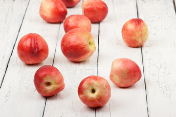 Ripe red peaches on the white wooden table