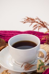 Obraz na płótnie Canvas Cup of black tea with autumn leaves and woolen cloth