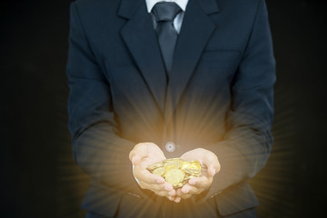 business man holding gold coin on black background
