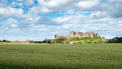 Fototapeta na wymiar Bamburgh Castle, England. A view over the Northumberland countryside in the north east of England towards the landmark castle at Bamburgh