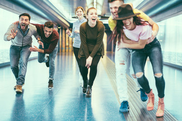 Happy friends having fun in underground metropolitan station - Young people hanging out ready for...