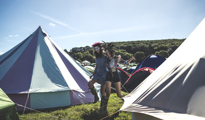 Glamping bell tents, traditional canvas tents in an enclosure on the camping grounds at an outdoor music festival.