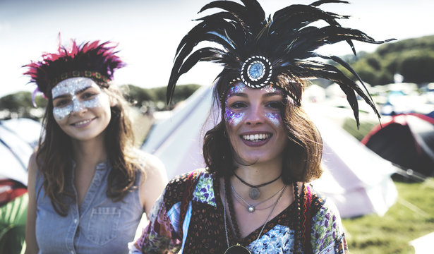 Two young women at summer music festival wearing feather headdress