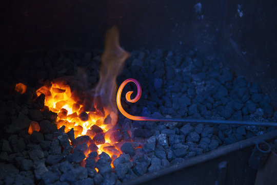Glowing coals in a fire and a red hot metal rod