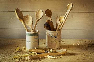 Handmade wooden spoons stored on a woodworker's bench. 