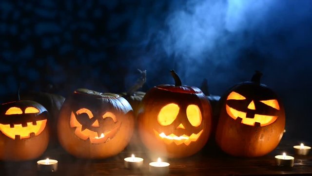 Halloween pumpkins with smoke and light beam, shadows at background, closeup sliding video