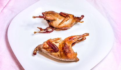 fried quail with fresh vegetables against white plate