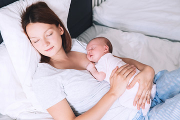 Newborn baby sleeping in the hands of his mother.