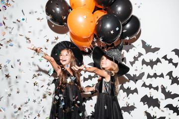 Couple of two smiling little girls dressed in halloween costumes