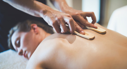 Masseur using wooden accessories to massage
