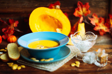 Pumpkin and carrot soup with cream and parsley on dark wooden background Top view