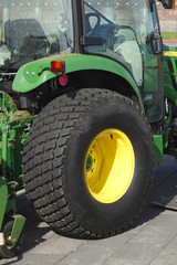 Schwarzer Traktor-Reifen, gelbe Radkappe