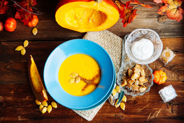 Pumpkin soup puree with spices on a wooden table