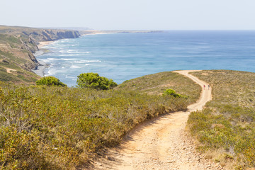 Couple hiking in Trail, mountains and vegetation in Arrifana
