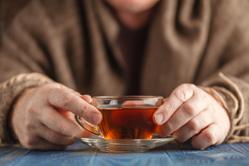 Hot tea in glass cup in male hands