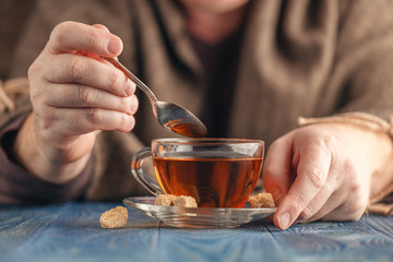 Hot tea in glass cup in male hands