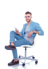 Young man sitting on chair and using mobile phone. Startupper. Young entrepreneur.