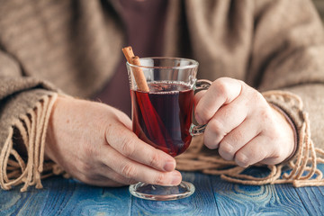 Fototapeta na wymiar Hot alcohol drink, mulled wine with spices in male hand