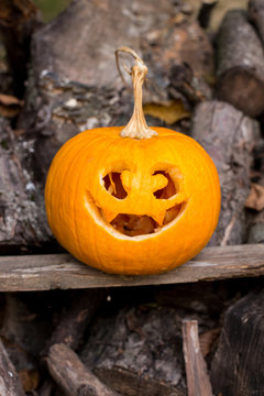 Halloween themes. Autumn halloween jack-o-lantern on autumn wooden background