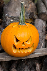 Halloween themes. Autumn halloween jack-o-lantern on autumn wooden background